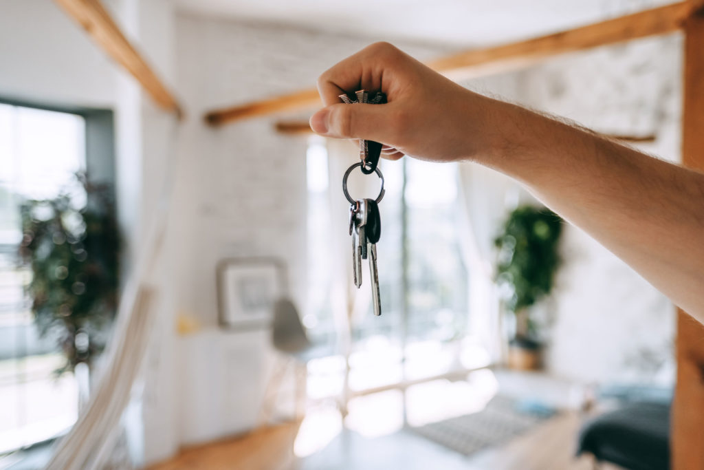 Mann hält Schlüssel in Wohnung in Thun nach Wohnung kaufen Thun, Bestätigung per E-Mail